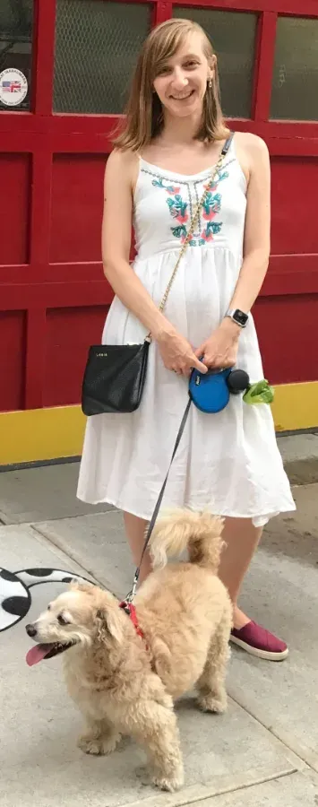 A team member walking her apricot poodle on a city sidewalk